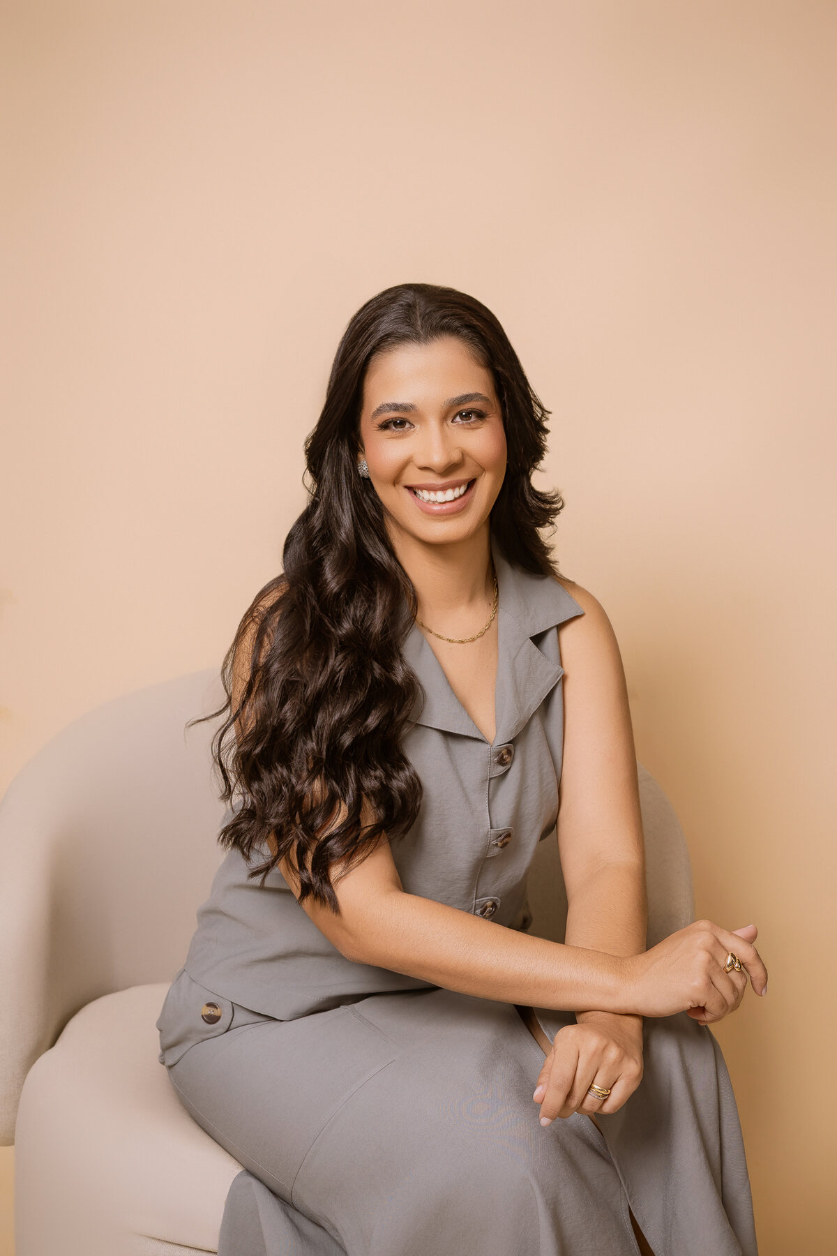 Dra. Raissa Viturino sentada, sorrindo, em ambiente de consultório